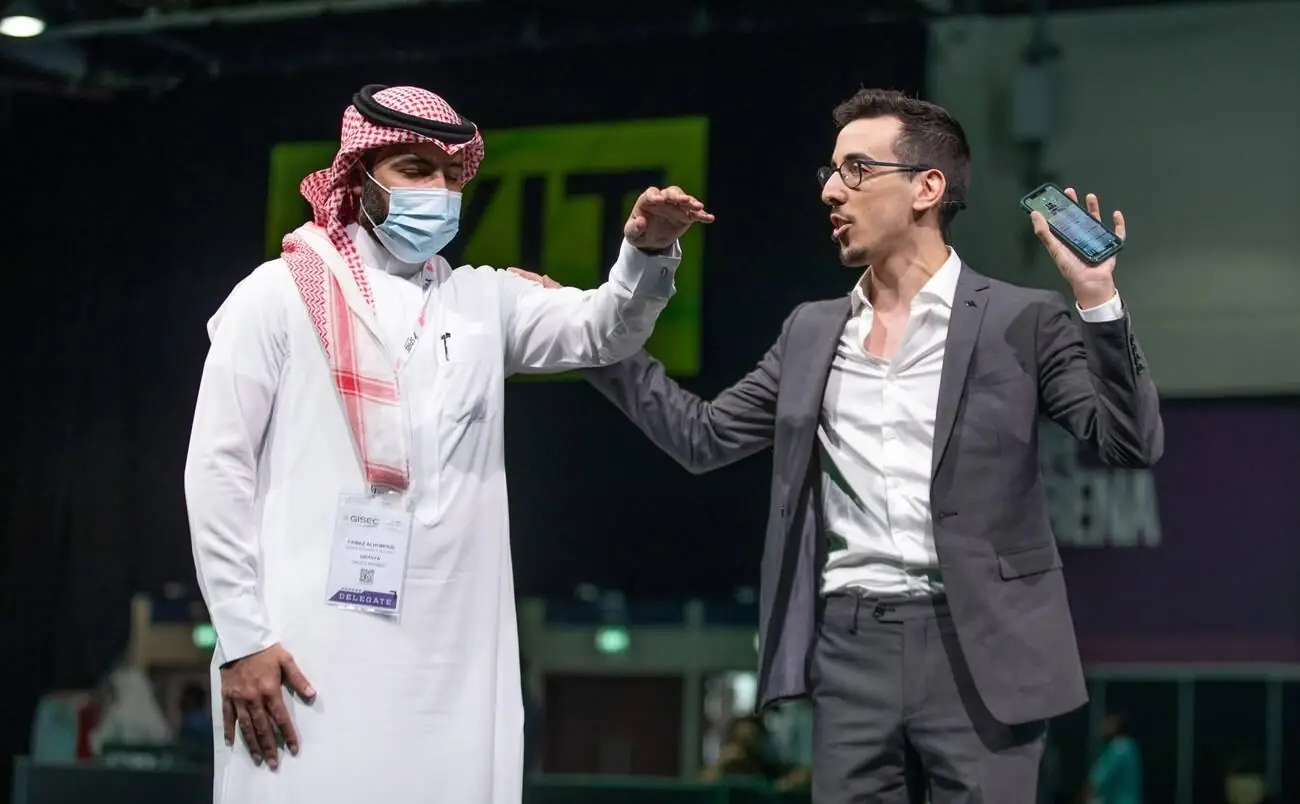 Ben Cale on stage with a participant at an international conference